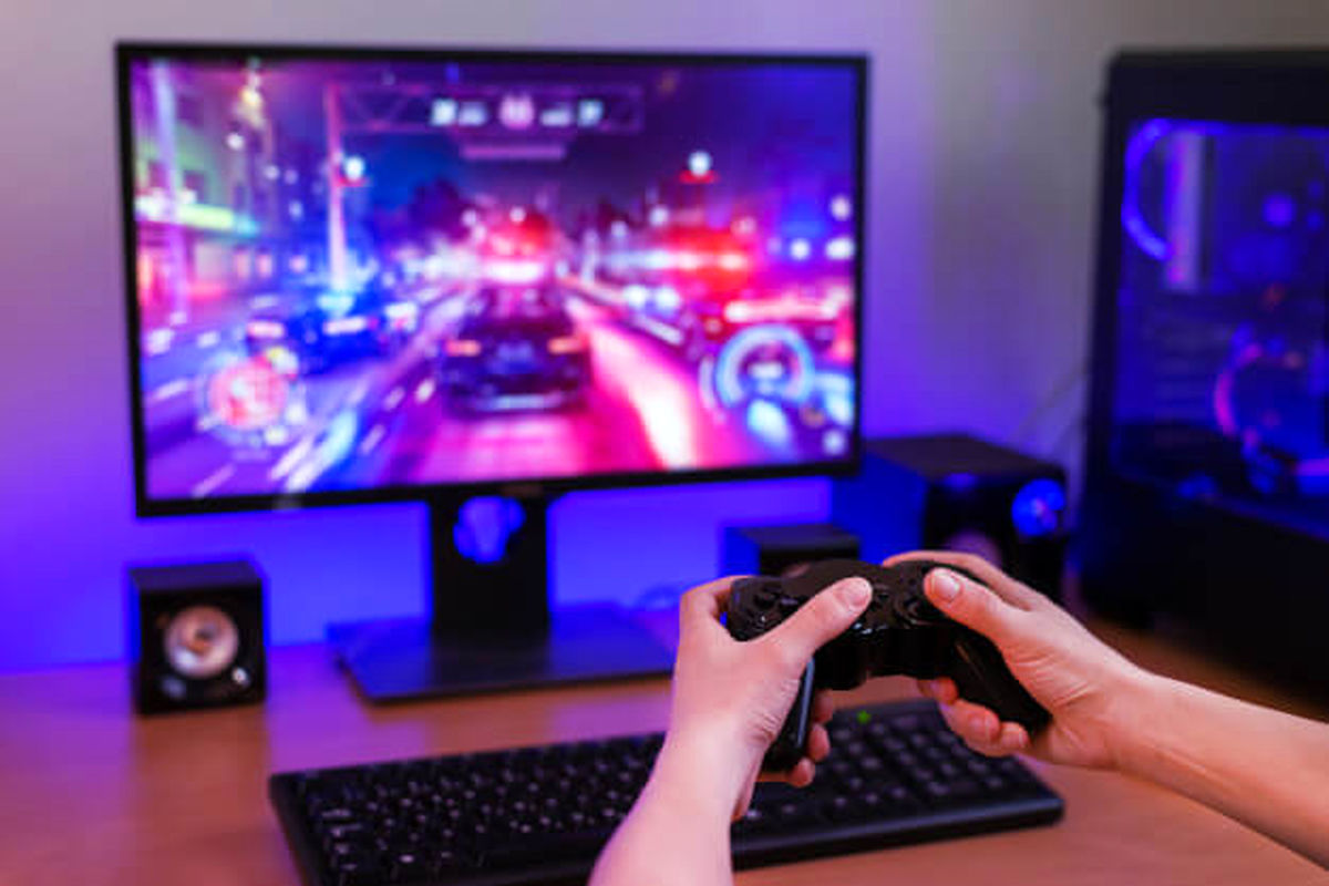 playing-racing-games-computer-concept-hand-holds-joystick-background-is-gaming-computer-with-rgb-light_176814-53